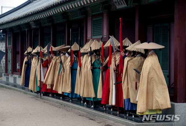 軒下で雨を避ける守門軍