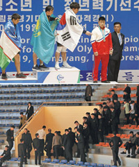 ▲25日、アジアユース・ジュニア重量挙げ選手権で優勝した韓国のヨム・ダフンが、3位の北朝鮮パク・クムイルに向かって「表彰台に一緒に立とう」と手を差し出したが、パク・クムイルはこれを拒否した。／写真＝聯合ニュース（上）

▲22日、アジアユース・ジュニア選手権観戦のため平壌市内の重量挙げ競技場を訪れた北朝鮮の観客たちは、韓国人選手の試合の順番になると一斉に席を立って会場の外に出た。／写真＝聯合ニュース（下）