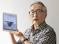 ▲独立軍の使っていたロシア製PM1910機関銃の写真を持って説明する朴桓・水原大学教授。／写真＝キム・ジホ記者 