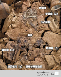 ▲慶尚南道昌寧郡校洞63号墳の石槨（せっかく）内から金銅冠、金耳飾、玉の頸飾（けいしょく）など被葬者の装身具が露出している様子。／国立伽耶文化財研究所 