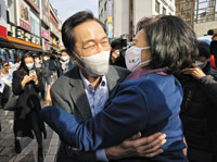 ▲今年4月のソウル市長補欠選挙の与党・共に民主党予備選挙に出馬する禹相虎（ウ・サンホ）議員＝写真左＝と朴映宣（パク・ヨンソン）前中小ベンチャー企業部長官＝同右＝。23日午前、ソウル市中区の南大門市場訪問行事で会い、ハグした。写真＝聯合ニュース 