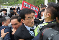 ▲5・18民主化運動41周年を迎えた今年5月18日午前、韓国政府主催の記念式が執り行われた光州市北区の国立5・18民主墓地の入り口でムン・フンシク会長の会場への入場を反対派たちが妨害し、もみ合いになった。／キム・ヨングン記者