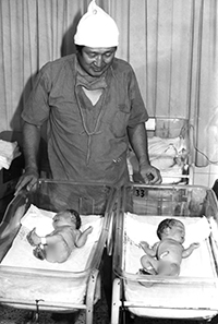 ▲韓国初の人工授精で生まれた赤ちゃんが成長し、このほど自然分娩で元気な赤ちゃんを産んだという。ソウル大学病院産婦人科のク・スンヨプ教授のチームが23日に伝えた。写真は1985年10月12日午前5時10分、ソウル大学病院の分娩室にて「試験管ベビー」を公開している張潤錫・産婦人科長（当時）。／写真＝ソウル大学病院提供