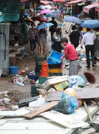 浸水被害にぼう然とする商店主たち　／ソウル