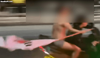【写真】男がバイクの後部座席で上半身裸になり、太極旗を振り回している。／ユーチューブより