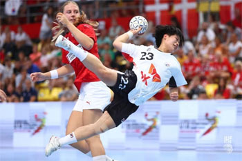 ▲8月11日（韓国時間）、ハンドボールの第9回世界女子ユース選手権決勝・韓国対デンマーク戦で、デンマークのDFをかわしてシュートしたキム・ミンソ。写真＝国際ハンドボール連盟　NEWSIS