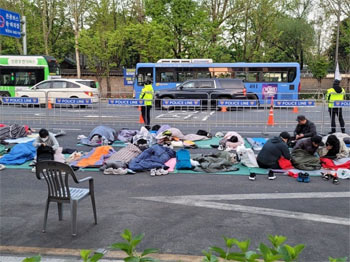▲21日午前、ソウル市中区のソウル広場横の車道で3車線にわたり、全障連の活動家や障害者などがむしろやマットを広げ、その上で横になっている。／写真＝読者提供