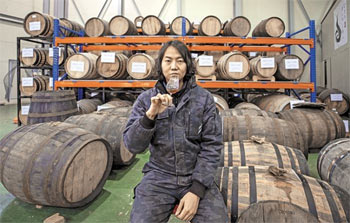 ▲2023年4月20日、京畿道金浦市内の「キム・チャンス・ウイスキー蒸留所」で、新たに開発中のウイスキーをグラスに注ぎ、香りを確かめるキム・チャンス代表。キム代表は韓国人初のシングル・モルト・ウイスキー生産者で、自身の名を冠した3種類のウイスキーを韓国の酒類市場に出した。キム代表の後ろに見えるオーク樽ではウイスキーの熟成が行われている。写真＝キム・ジホ記者