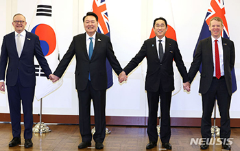 手をつなぐ韓国・日本・豪州・NZ首脳