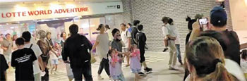 ▲28日午後、ソウル市松坡区蚕室のロッテワールドで、火災発生・避難を呼びかける放送を聞き、外に出る人々。写真＝ツイッターより