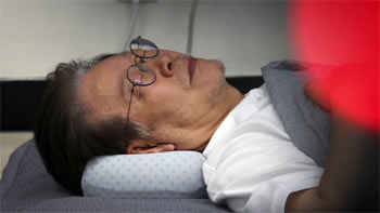 ▲13日、国会事務室で横たわる共に民主党の李在明（イ・ジェミョン）代表。ハンガーストライキ開始から14日目の様子。写真＝共同取材団