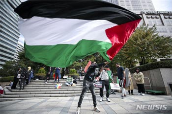 ▲10月22日、ソウル市中区のソウル・ファイナンスセンター前で行われた「イスラエルはパレスチナ人の集団虐殺をやめろ」と題する集会で、パレスチナの旗が広げられている。