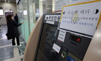 ▲韓国全国の地方自治体で行政コンピューターネットワークに障害が発生した17日午前、ソウル市内のある区庁（区役所）では、総合書類発行室内の無人書類発行機にネットワーク障害に関する案内文が貼られていた。写真＝聯合ニュース