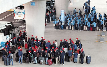 ▲昨年7月、仁川国際空港に到着した外国人労働者たち。各地域に向かうバスに乗るために並んで待っている様子。写真＝聯合ニュース