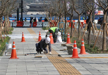 ▲ソウル・世宗大路の歩道で敷石を再整備作業を行う関係者たち。／チャン・リョンソン記者
