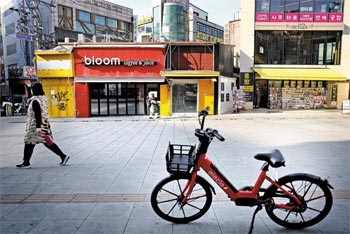 ▲1月31日、ソウル市西大門区滄川洞の新村。がらんとした売り場の前を通り過ぎる市民たち。／チュ・ミンウク映像メディア記者