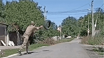 ▲地雷を爆発させるためタイヤを投げるウクライナ軍兵士　／テレグラム