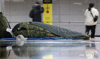 ▲ソウル駅の地下道で、寝袋の中で寒さをしのぐ路上生活者。1月23日午後撮影。