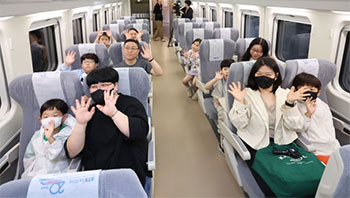 ▲4月22日午後、ソウル市竜山区のソウル駅で開かれたKTX青竜の試乗イベントで、試乗団が取材陣に向けて手を振っている様子。／NEWSIS