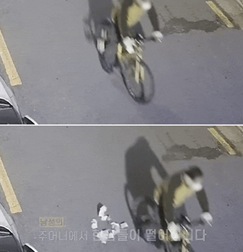 ▲今年2月、慶尚南道河東郡で、自転車に乗っていたある男性が現金を落とした様子。写真＝韓国警察庁