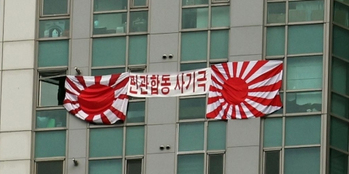 ▲顕忠日当日の今月6日、釜山市水営区の住商複合タワーマンションの窓に設置された旭日旗／NEWSIS