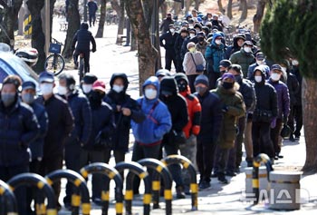 強い寒さの中、無料給食の列に並ぶ高齢者