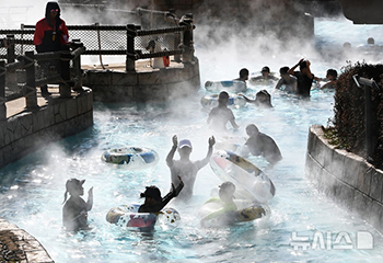寒波の中でも野外温水プールを楽しむ市民