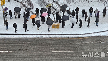 雪道で出勤のためバスを待つ人々　／京畿道