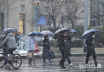 降りしきる雪の中、傘をさして出勤　／ソウル
