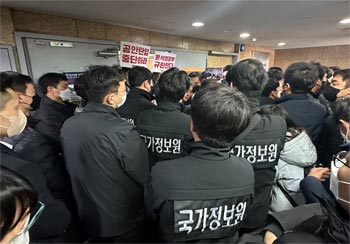 ▲ソウル市中区の全国民主労働組合総連盟（民主労総）オフィスを家宅捜索しようとする国家情報院と警察の捜査官。民主労総関係者らがこれを阻止している。2023年1月18日撮影。／コ・ウンホ記者