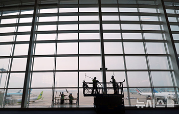 仁川空港でターミナルのガラス壁を清掃