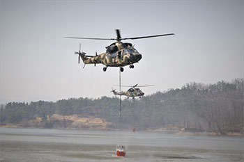 ▲慶尚北道義城郡安渓面の貯水池で山火事消火作業用の水をくむ韓国陸軍のヘリコプター「スリオン（KUH1）」。27日撮影。／写真＝陸軍