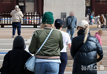 花冷えの一日　厚着する観光客たち　／ソウル