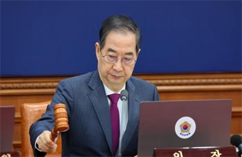 ▲韓悳洙大統領権限代行首相が14日、ソウル市鍾路区の政府ソウル庁舎で開かれた国務会議（閣議に相当）で議事棒を打っているところ。／写真＝首相室提供