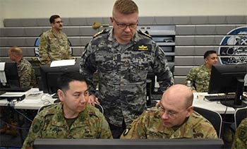 ▲米軍と自衛隊統合幕僚監部の隊員、オーストラリア軍が、昨年2月の「キーン・エッジ2024」演習当時、米空軍横田基地で作戦を協議している様子。／写真＝在日米軍