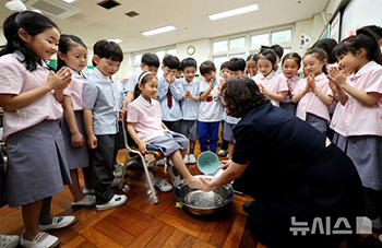 「先生の日」に子どもたちの足を洗う先生　／大邱