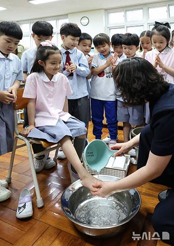 「先生の日」に子どもたちの足を洗う先生　／大邱