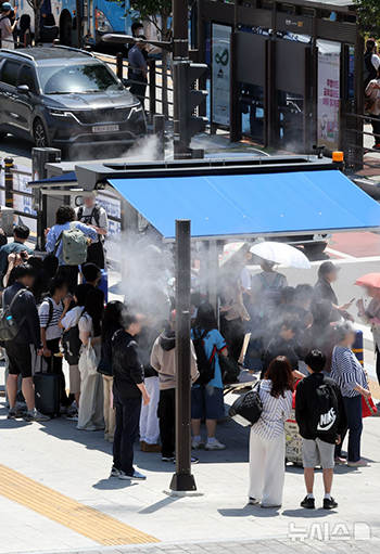 「日よけの下でクーリングフォグに当たって暑さを紛らわせましょう」