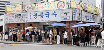 蒸し暑さの中、冷コングクス店前には入店待ちの行列