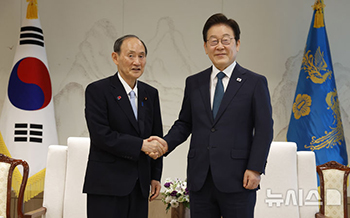 握手をする李在明大統領と菅義偉・元首相