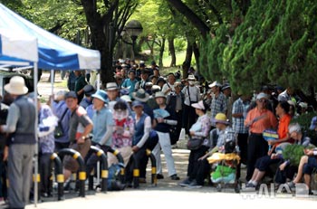 猛暑の中、無料給食の順番を待つ高齢者