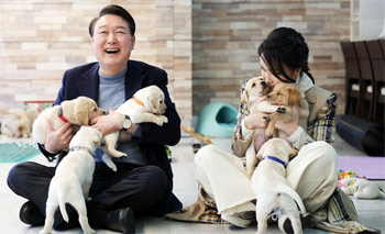 ▲2022年12月24日、京畿道竜仁市内のサムスン火災盲導犬学校で、子犬たちと一緒に写真撮影をする尹錫悦（ユン・ソンニョル）大統領＝当時＝夫妻。尹前大統領夫妻はこの日、「セロミ」という名前の引退した盲導犬を1匹引き取った。写真＝韓国大統領室