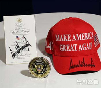 ▲ホワイトハウス記念メダルとトランプ大統領がサインした「MAGA」帽子、昼食会メニュー　／NEWSIS  