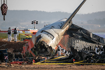 ▲昨年12月31日、務安空港で起きたチェジュ航空7C2216便の事故現場を調査する警察の科学捜査隊。／チャン・リョンソン記者