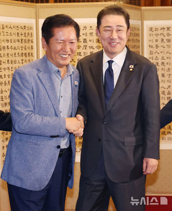 握手する共に民主党・鄭清来代表と金炳基院内代表