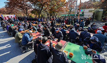 寒さの中、並んで無料給食を待つお年寄り