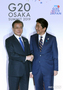 G20大阪：向かい合って握手する韓日首脳
