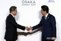 G20大阪：向かい合って握手する韓日首脳