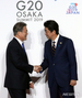 G20大阪：向かい合って握手する韓日首脳