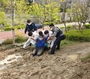 ▲13日、釜山市東莱区でぬかるみに下半身がはまったAさんを救急隊員と警察官が救助した。写真＝釜山警察庁 